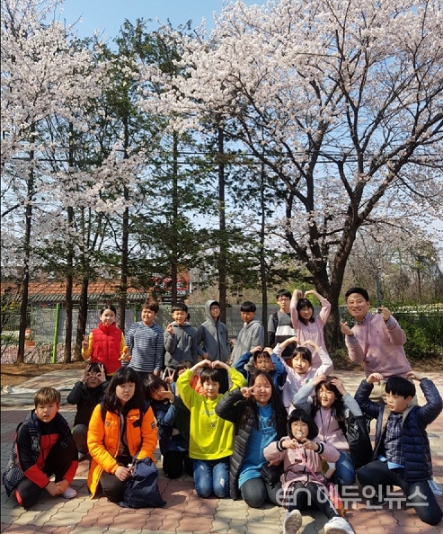 학교 교문 앞 벚나무 아래에서 반 아이들과 찍은 단체 사진. 최창진 교사는 "벚나무는 올여름 사라진다"며 "말 그대로 벚꽃엔딩"이라고 표현했다. 사진=최창진교사