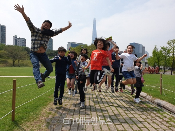 서울 롯데타워를 배경으로 단체로 찍은 점프 샷. 사진=최창진교사
