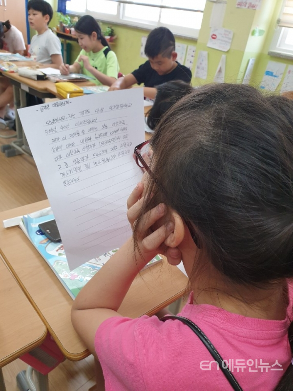 문재인 대통령에게 손 편지를 쓰면서 생각에 잠겨 있는 문기초등학교 학생 모습(사진=문기초 교사 최창진)