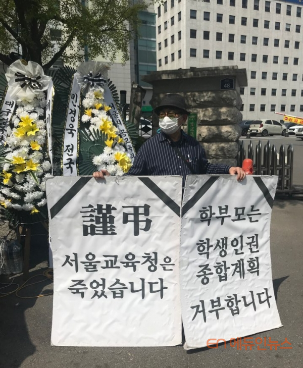 21일 서울시교육청 앞에서 학생인권교육 철회를 요구하는 학부모가 피켓을 들고 서 있다. 사진 에듀인뉴스