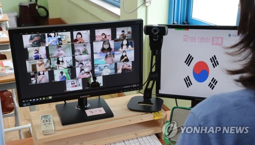 20일 서울 도봉구 방학초등학교에서 열린 온라인 여름 방학식에서 학생들이 국기에 경례하고 있다. 사진 연합뉴스